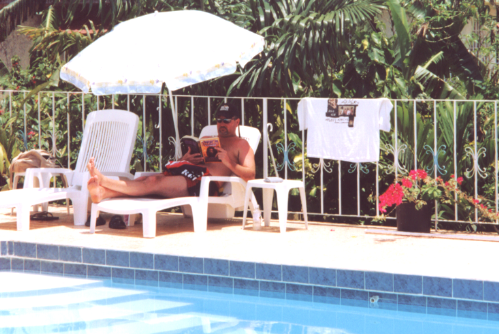 Brad relaxing & reading "Catch A Fire" poolside @ Seastar Inn