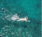 EZE snorkels in the clear water below